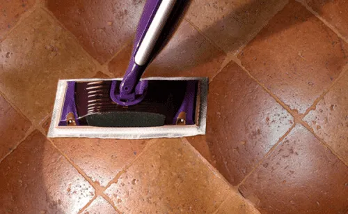 Mop che pulisce sul pavimento in cotto