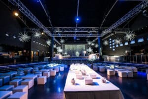 Sala ricevimenti con un tavolo centrale lungo bianco, sedute ai lati e luci soffuse