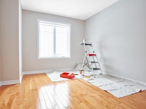 Stanza appena imbiancata con scala e telo di protezione